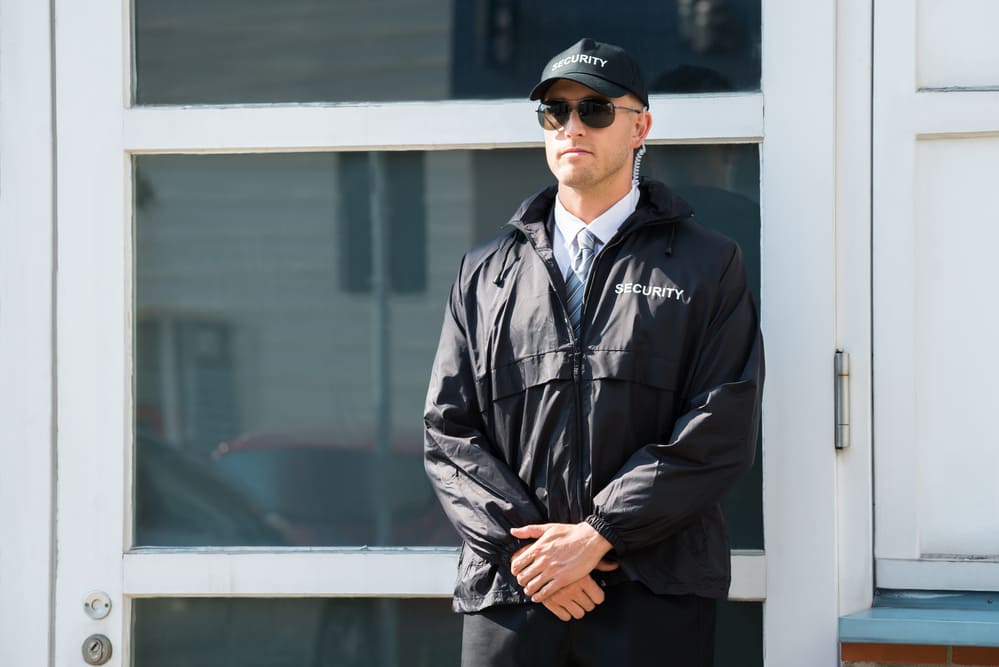 Agent de sécurité posté à l'entrée d’un bâtiment professionnel